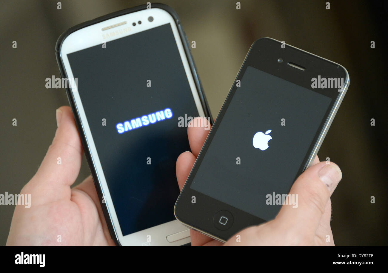 ILLUSTRATION - A woman holds an Apple iphone 4s (R) and a Samsung Galaxy S3 in her hands in Hamburg, Germany 30 Amrch 2014. The patent dispute between rivals Apple and Samsung is entering the second round with a trial that started in California, USA, on 31 March 2014. Photo: Marcus Brandt/dpa Stock Photo