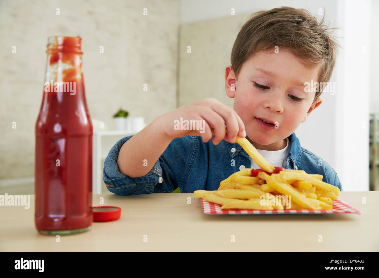 Germany, Munich, Boy eating French fries with ketchup Stock Photo Alamy