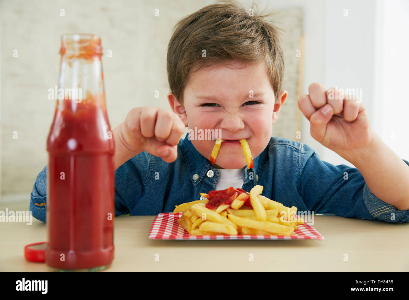 Germany, Munich, Boy eating French fries with ketchup Stock Photo Alamy