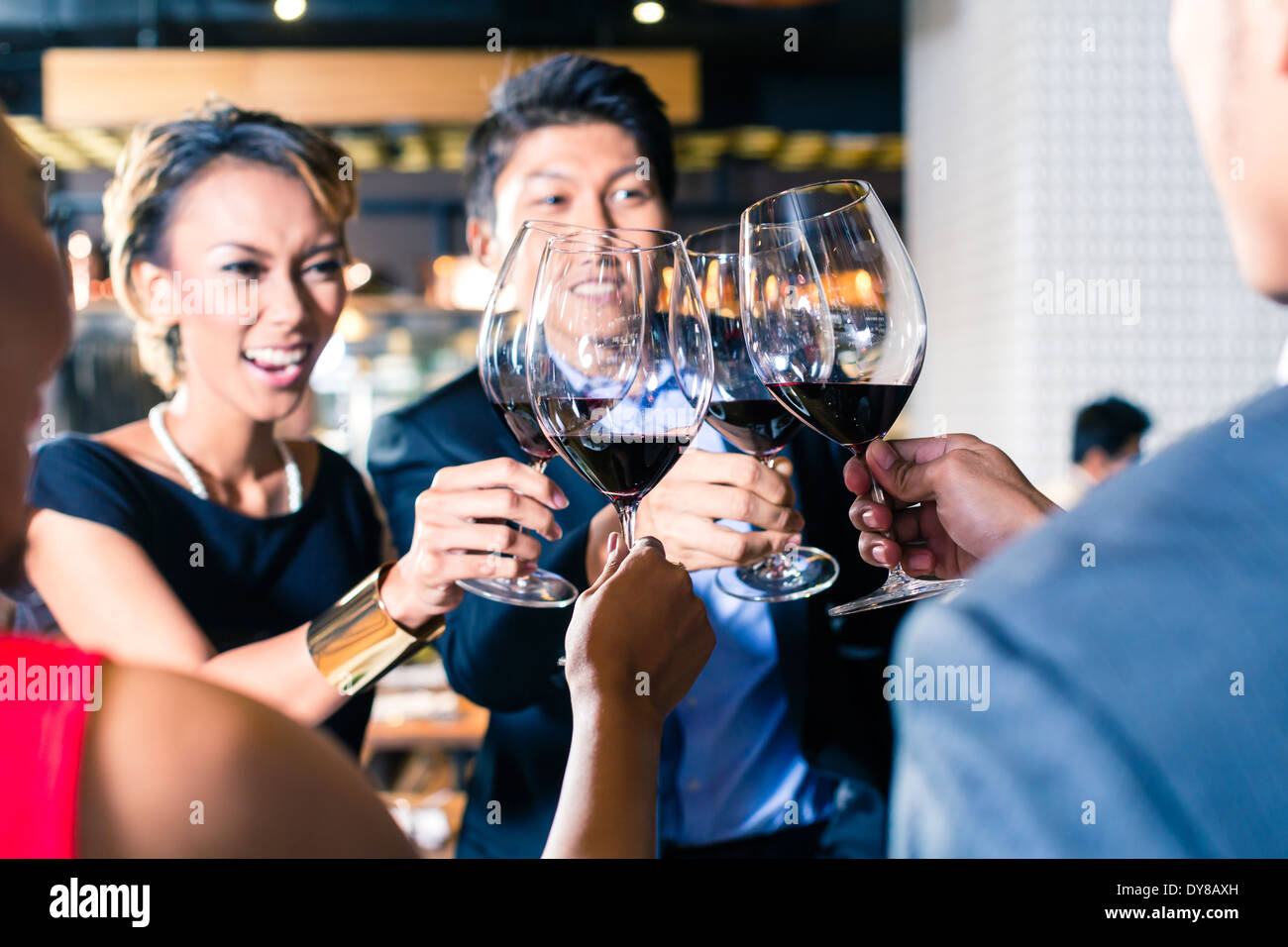 Asian friends clinking glasses Stock Photo