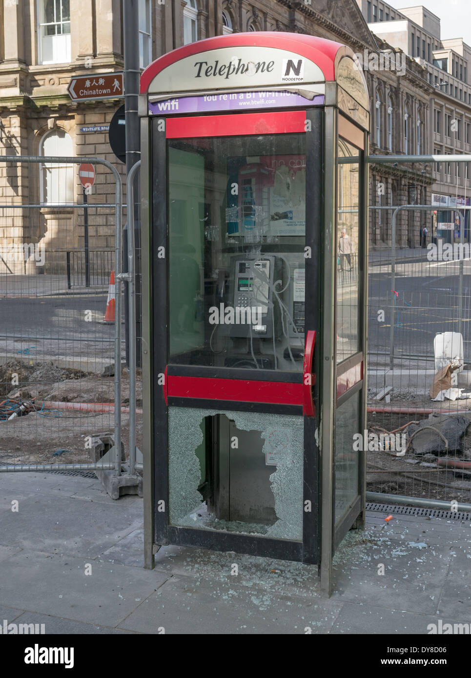 Vandalised telephone box or kiosk with broken glass door Newcastle north east England UK Stock Photo