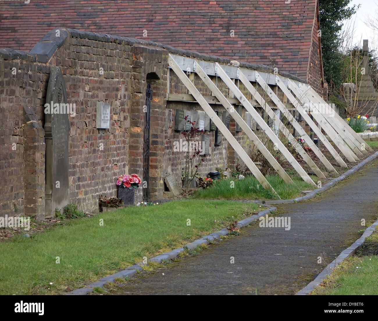 wooden-buttressing-supporting-an-unstable-wall-st-michaels-churchyard-DY8ET6.jpg