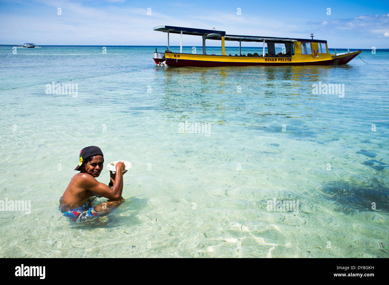 local man eating in the water, Gili island, Lombok, Indonesia, Asia Stock Photo