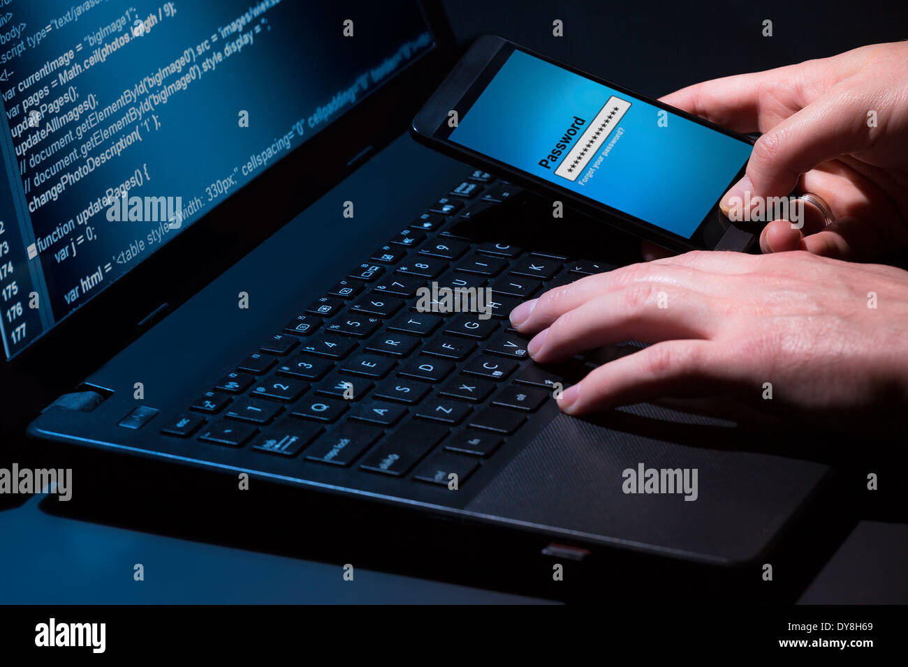 Hacker using laptop. Lots of digits on the computer screen. Stock Photo