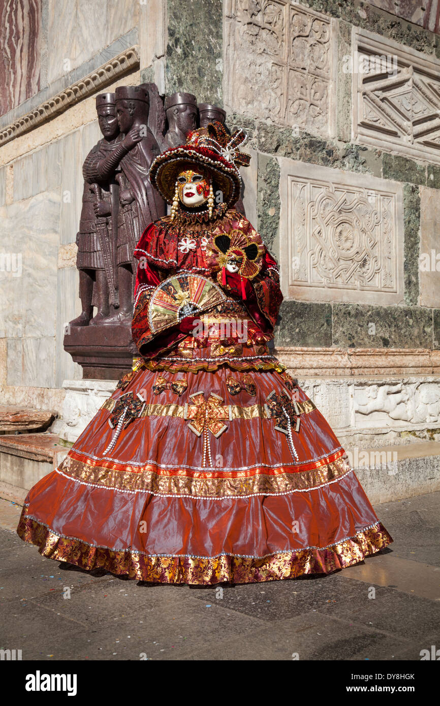 Woman in beautiful historic Venetian fancy dress costume posing at Four Tetrarchs Statues, St Mark's Square, Venice, Carnival di Venezia, Italy Stock Photo