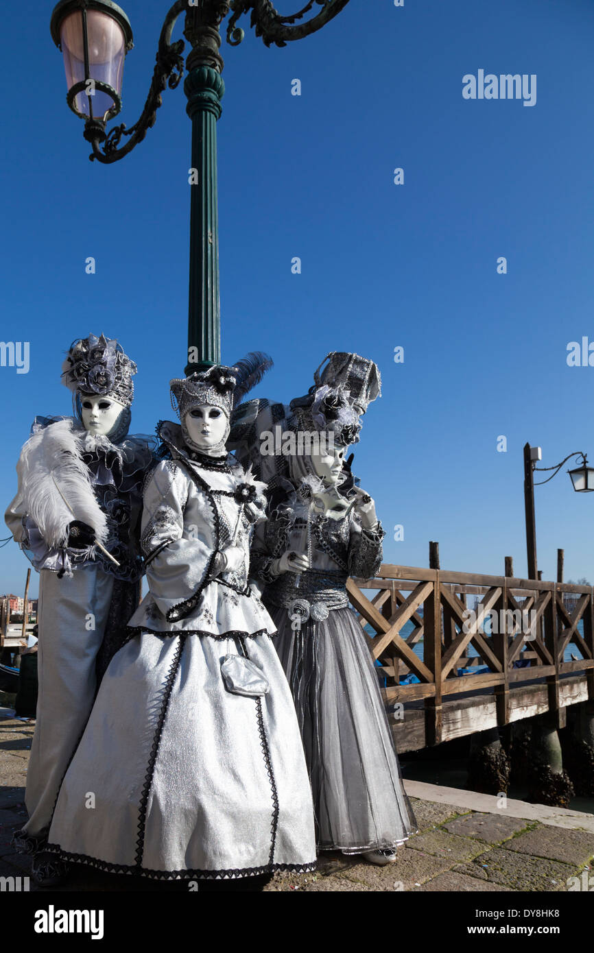 Group of three women in white historic fancy dress costumes and masks by  the lagoon,Venice carnival, Carnevale di Venezia, Italy Stock Photo - Alamy