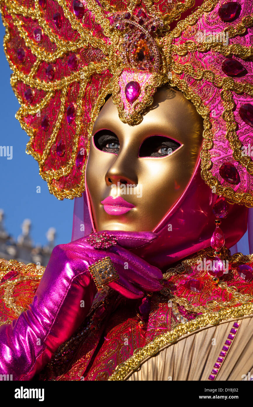 Carnevale di Venezia, close up portrait of woman in golden mask and bright pink fancy dress costume, during the Venice carnival, Italy Stock Photo