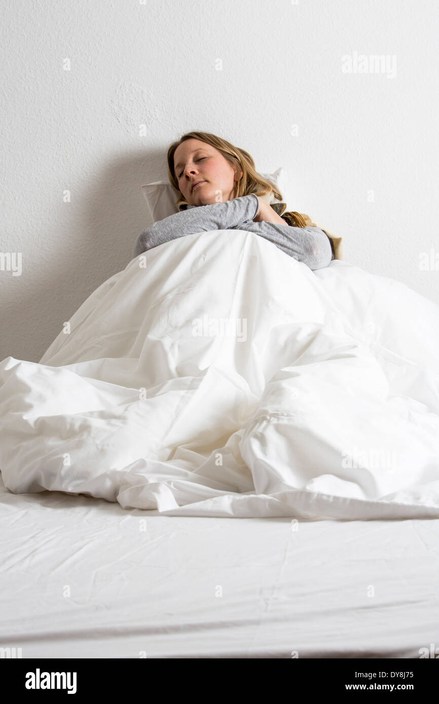 Young woman feels has a cold, flu, lying in bed Stock