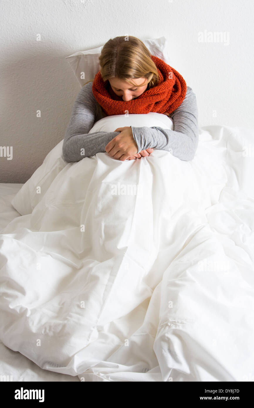 Young woman feels has a cold, flu, lying in bed Stock