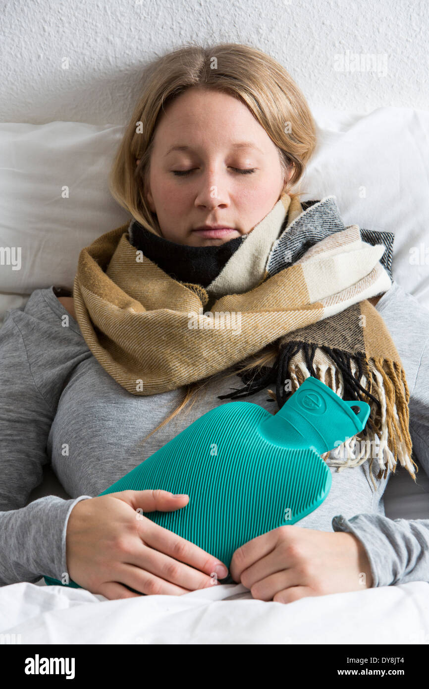 Young woman in pain, relieves the pain associated with a hot water