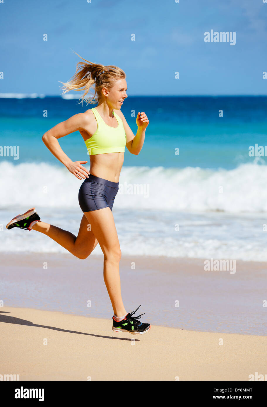 Athletic Fitness Woman Running on the Beach. Female Runner Jogging. Outdoor Workout. Fitness Concept. Stock Photo