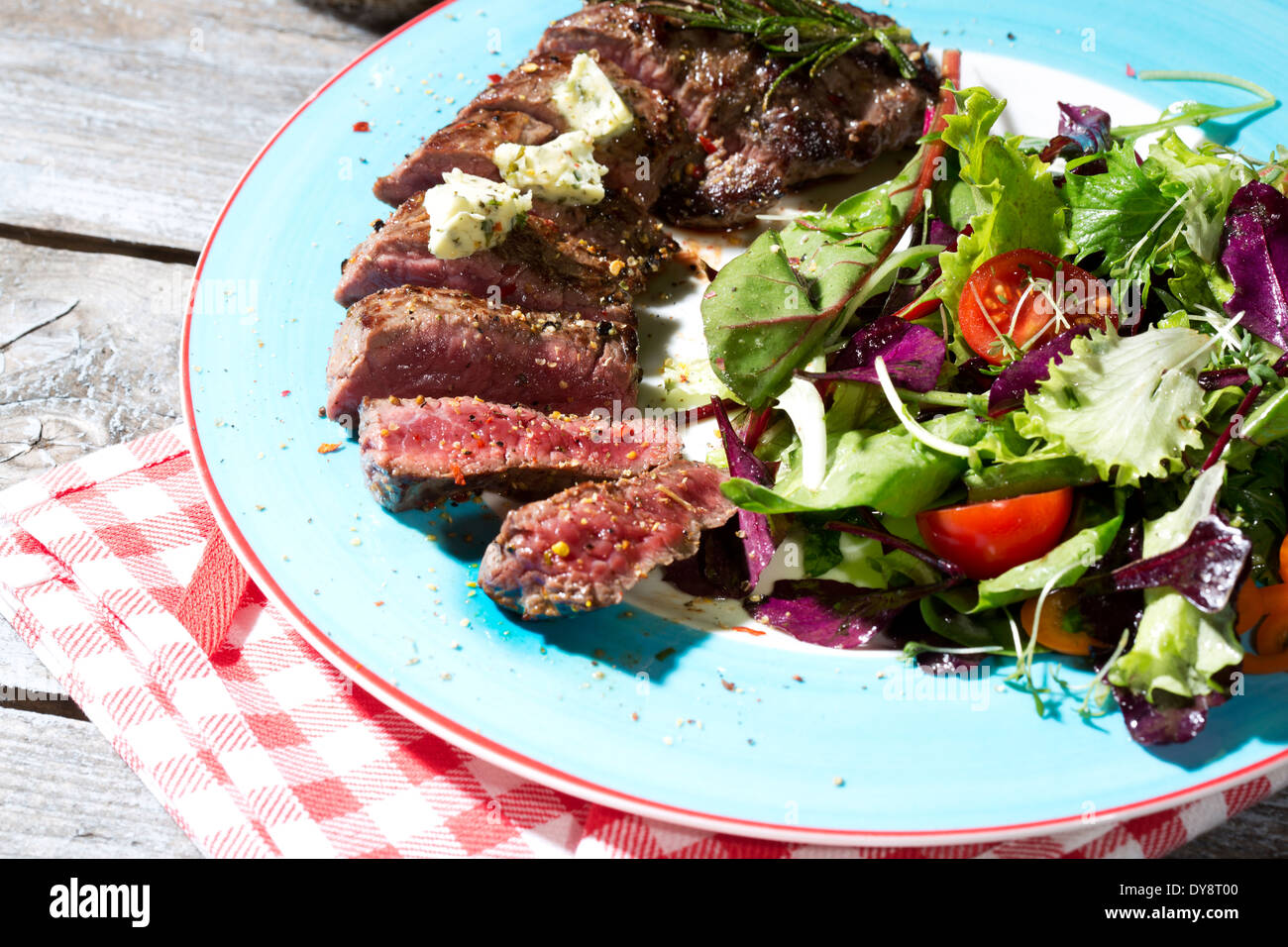 Beef sirloin steak with rosemary, garlic, herb butter, pepper and salad