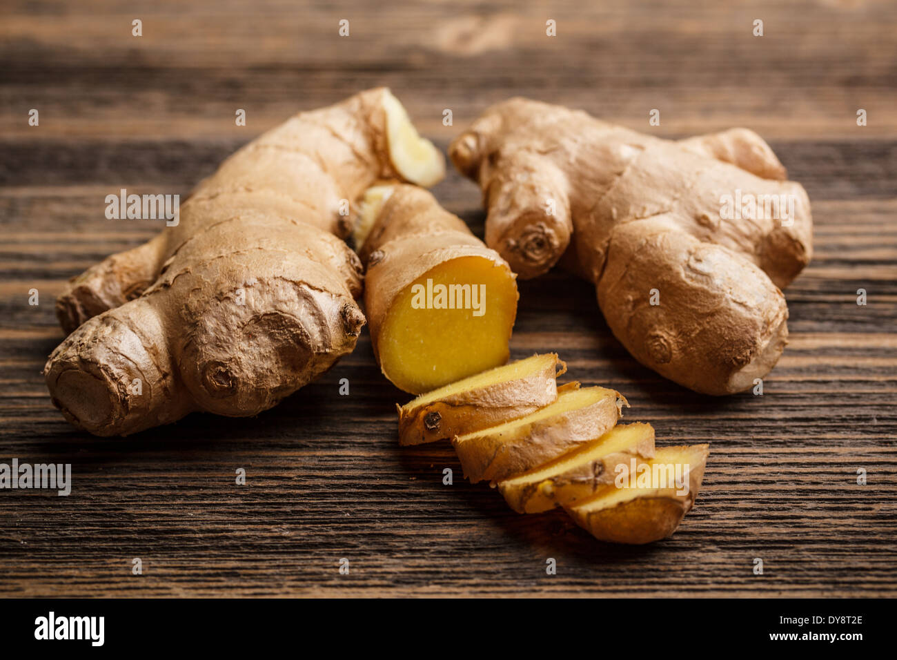 Fresh ginger, whole and sliced on rustic wooden background Stock Photo