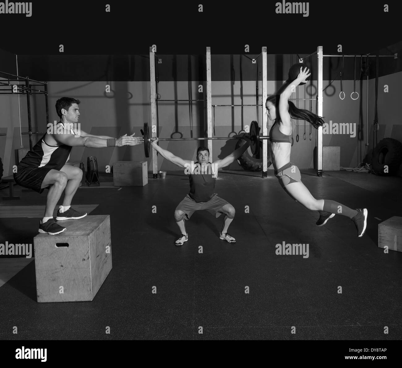 gym people group workout barbells slam balls and jump exercises Stock