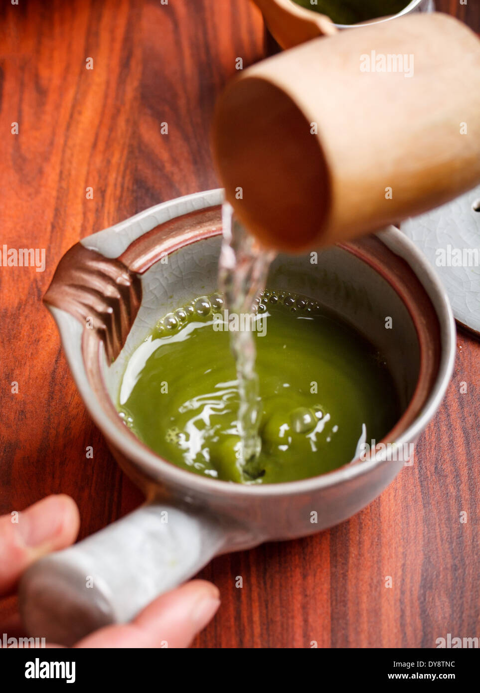Tea master pouring water onto matcha tea Stock Photo