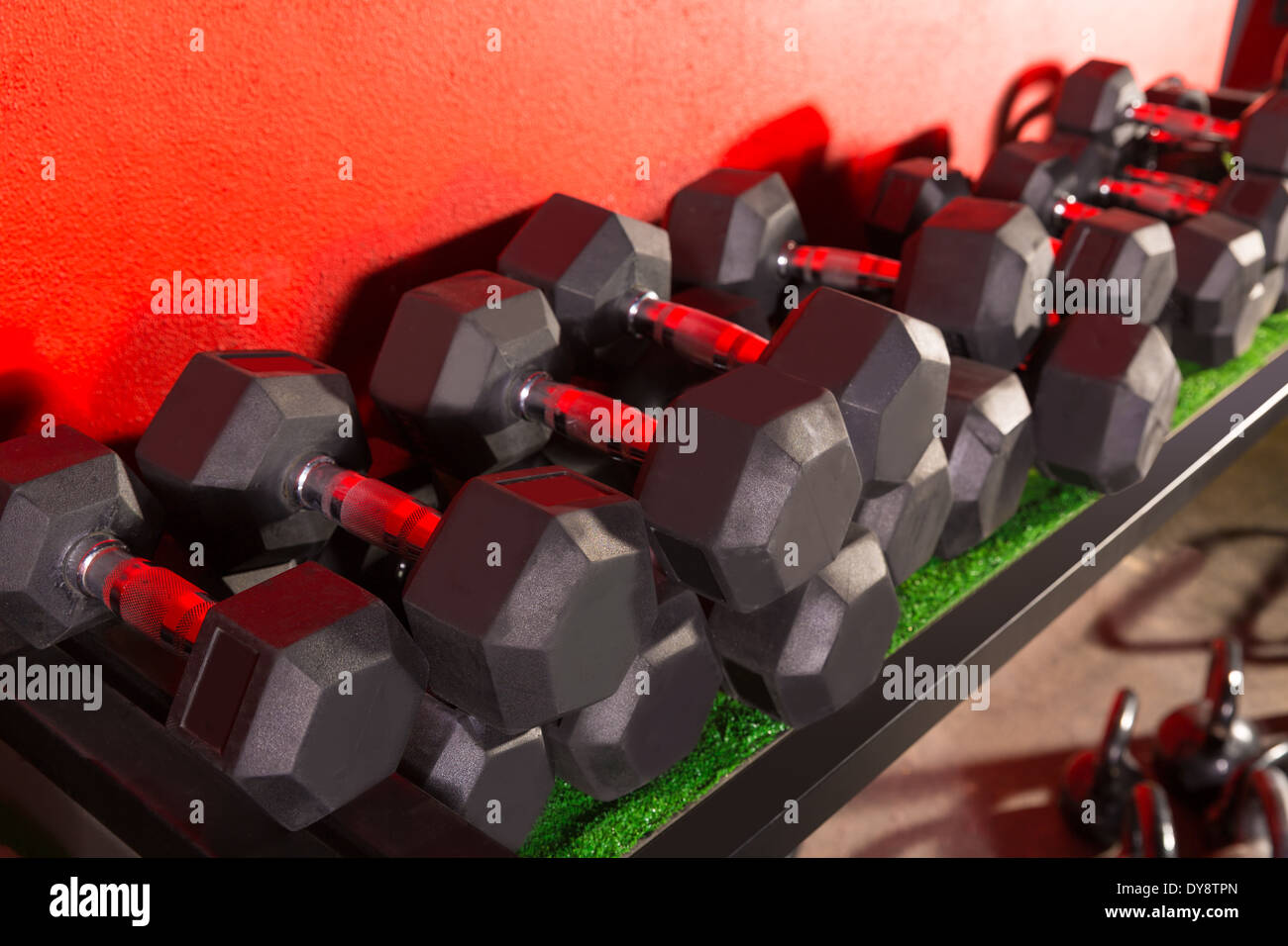 Dumbbells and Kettlebells weight training equipment at gym Stock Photo