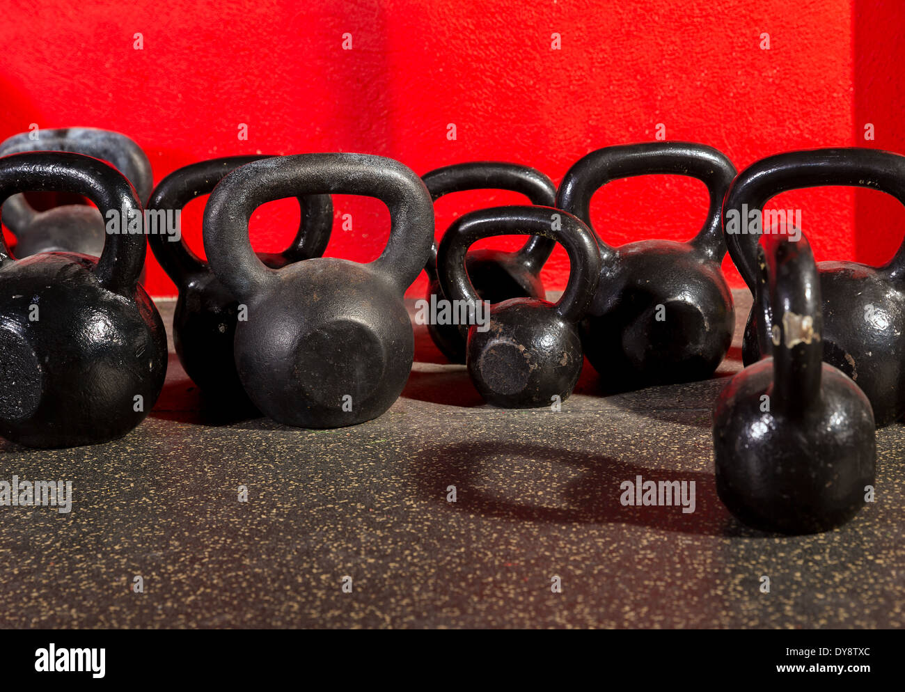 Kettlebells weights in a workout gym in red background Stock Photo
