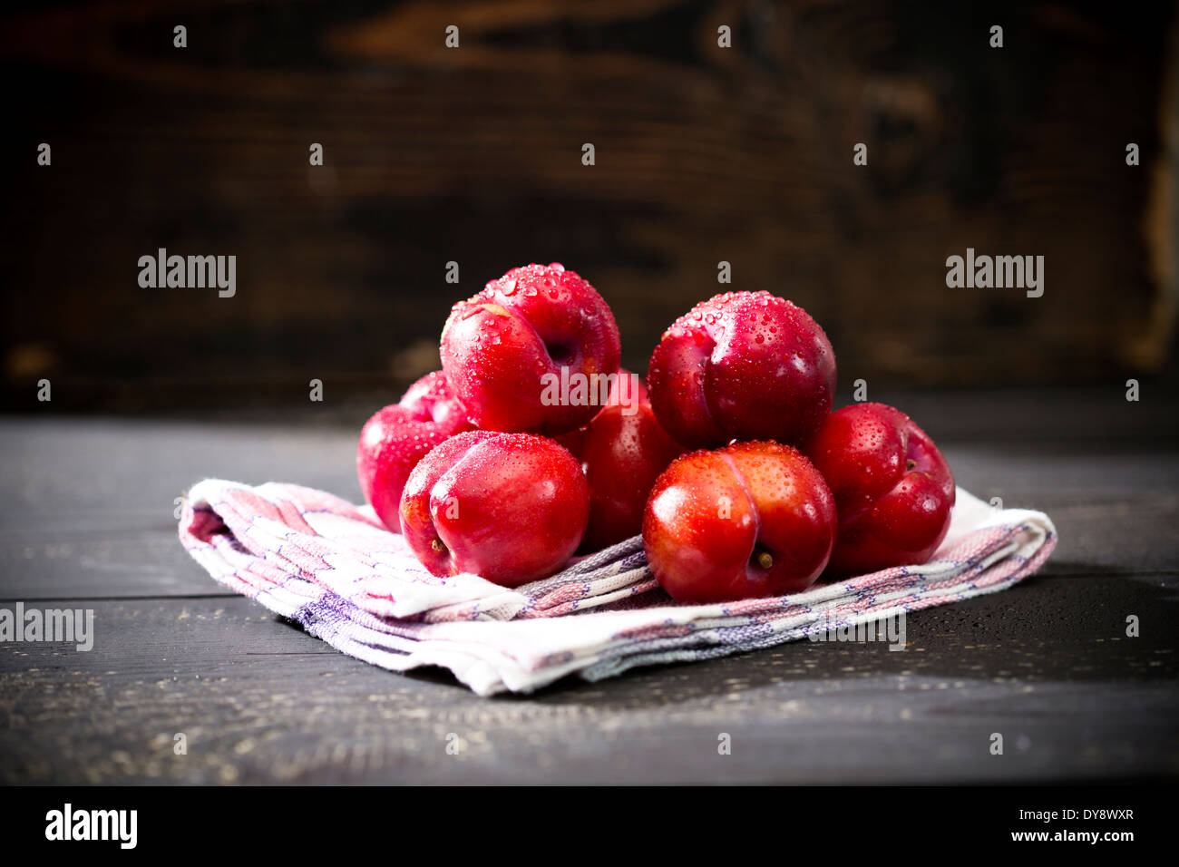 Pile of Chinese plums (Prunus salicina) on kitchen towel and dark wooden table Stock Photo Alamy