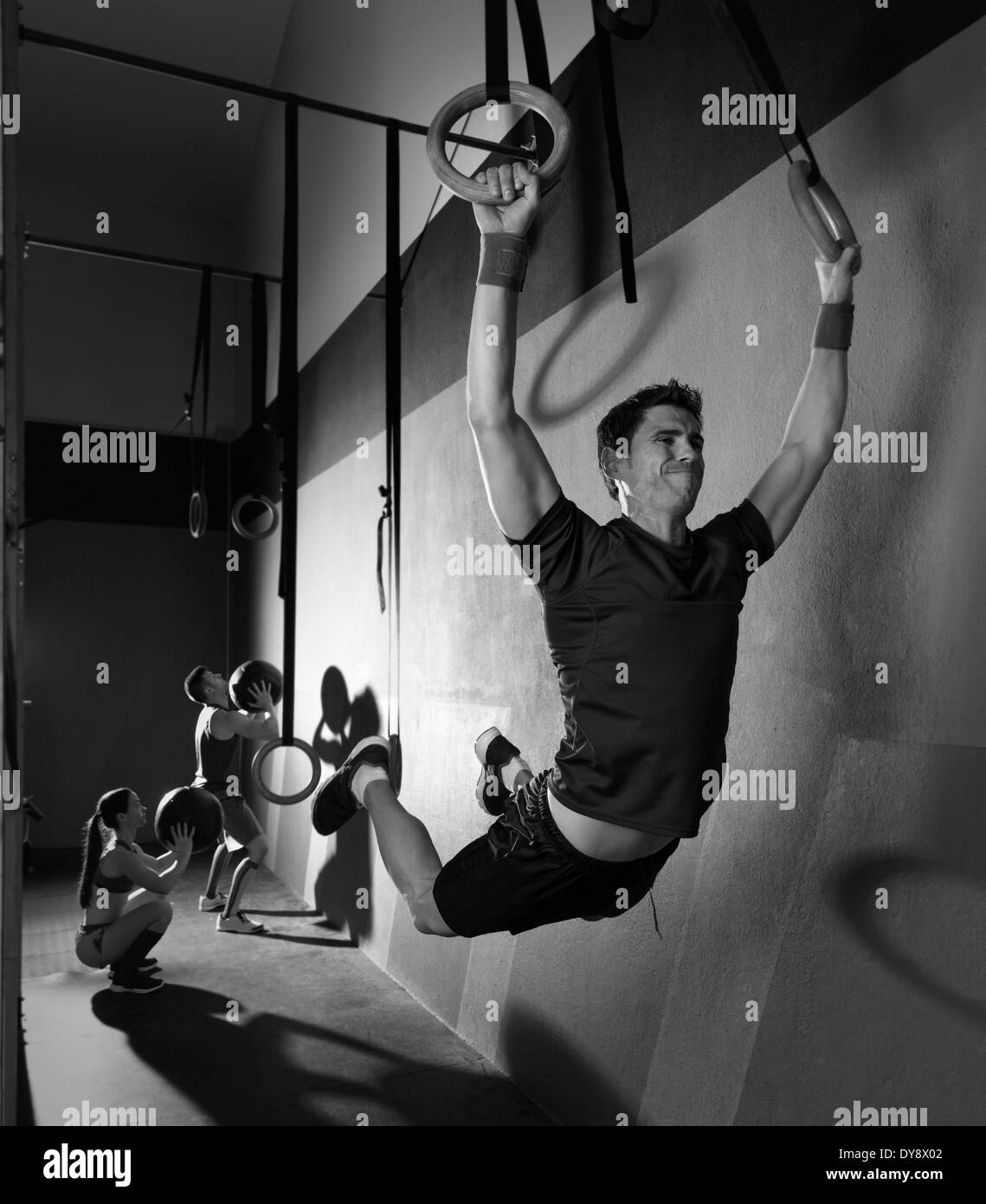 Muscle ups rings man swinging workout exercise at gym Stock Photo