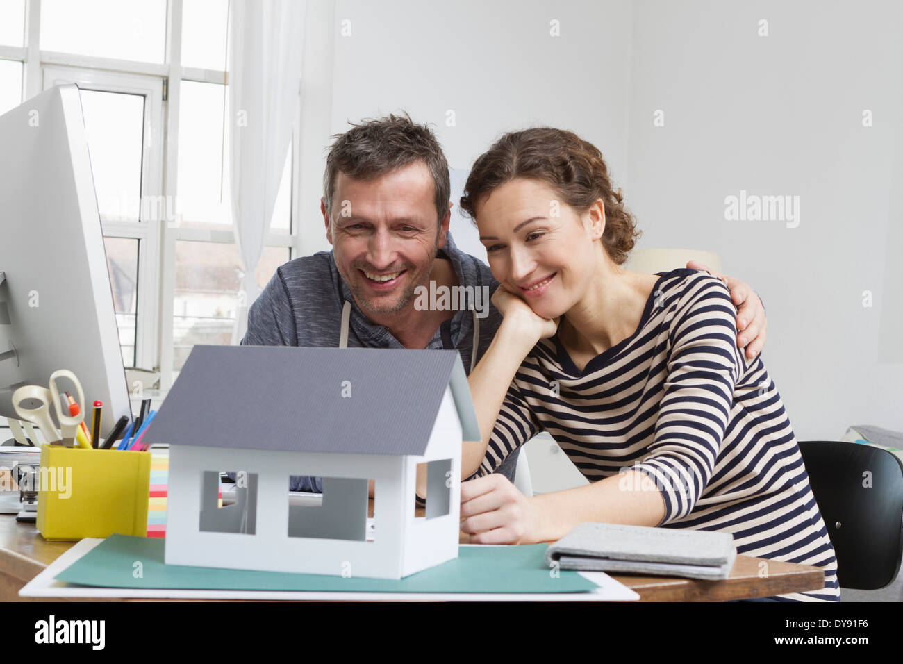 Couple at home with model house Stock Photo