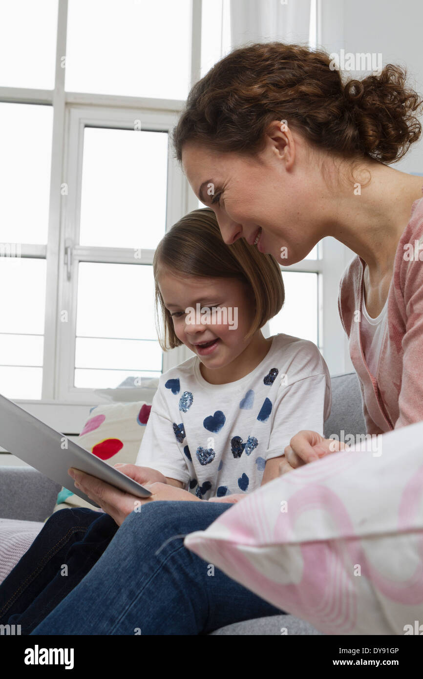 Mother and daughter on couch with tablet computer Stock Photo