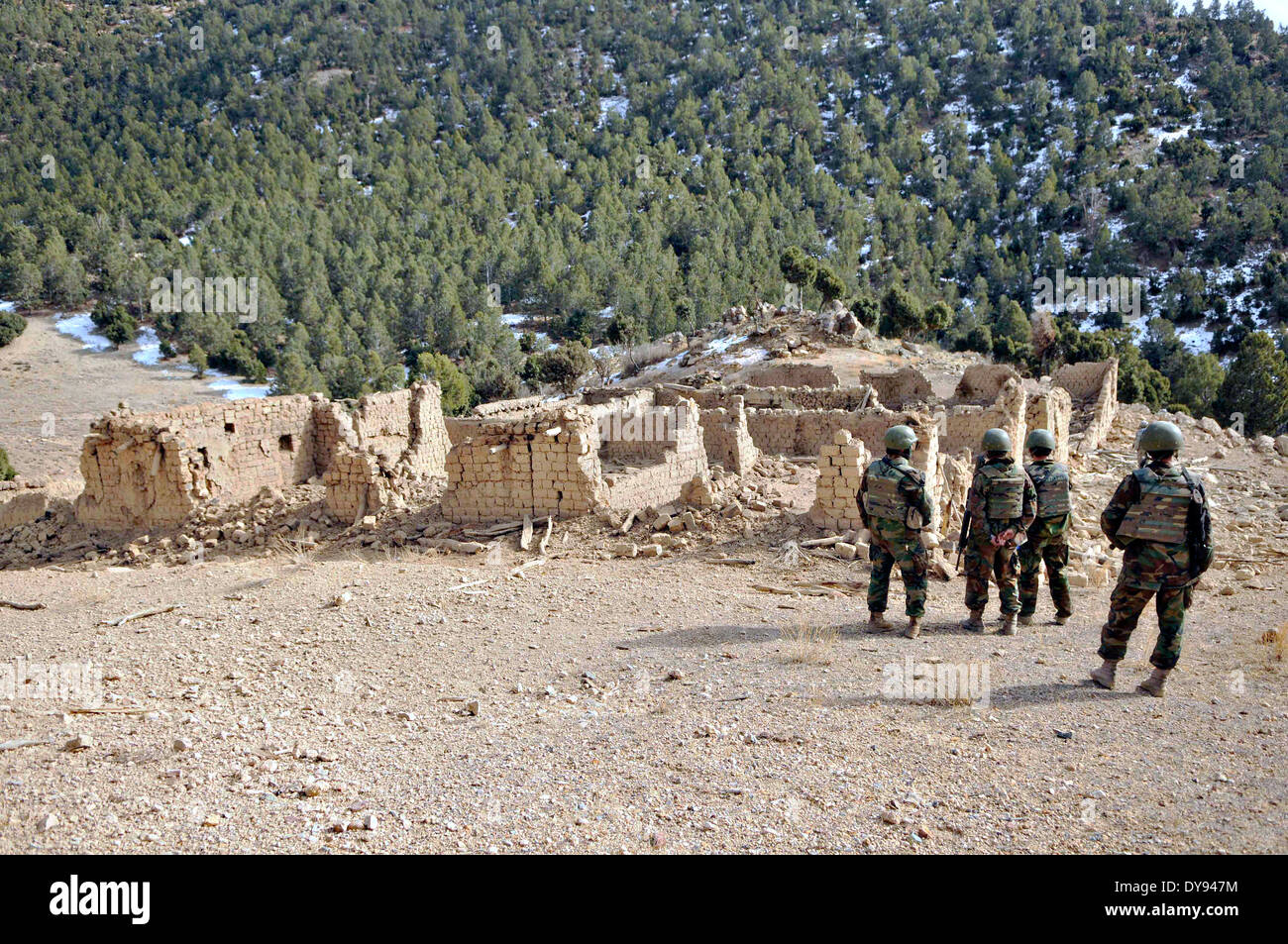 Afghan National Army soldiers view the rubble left behind after US soldiers placed C-4 explosive charges inside a wall to destroy a Taliban safe house once used by insurgent fighters December 18, 2009 in Khost province, Afghanistan. Stock Photo