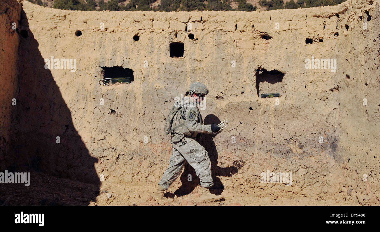 US Army Staff Sgt. Dennis Speek with the 707th Explosive Ordnance Disposal Company, places C-4 explosive charges inside a wall to destroy a Taliban safe house once used by insurgent fighters December 18, 2009 in Khost province, Afghanistan. Stock Photo