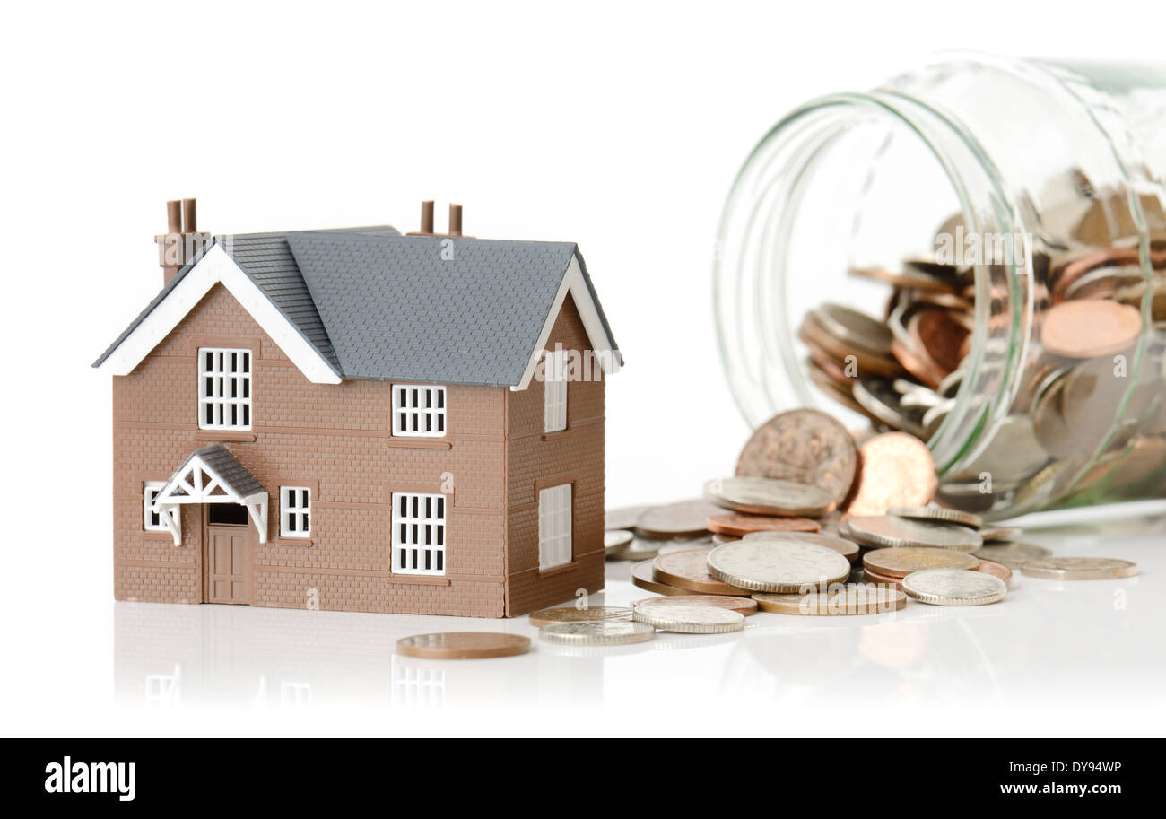 Concept for cost of living or housing a model house with coins Stock Photo