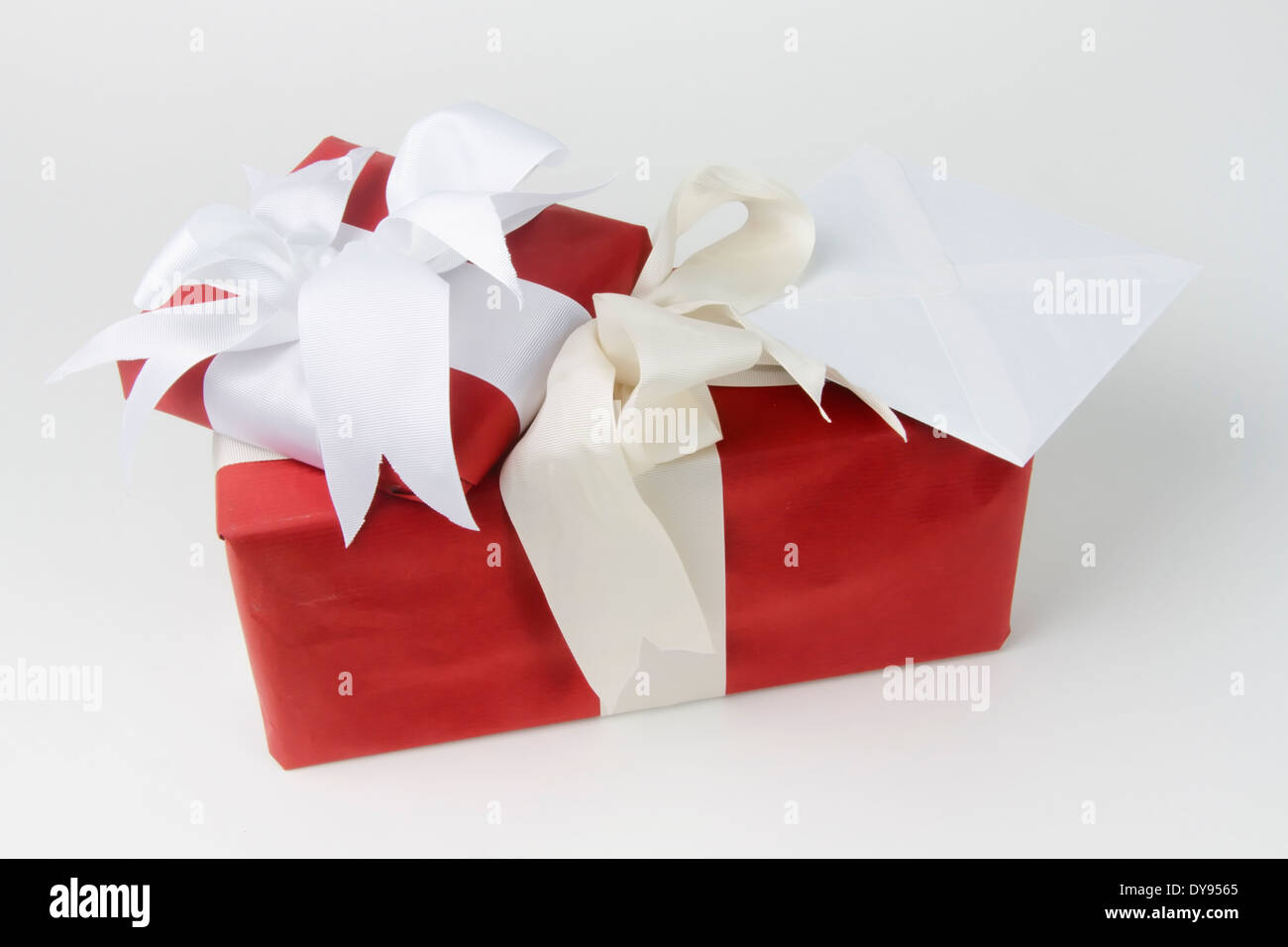Two gift wrapped presents with bows plus a greeting card in an envelope Stock Photo