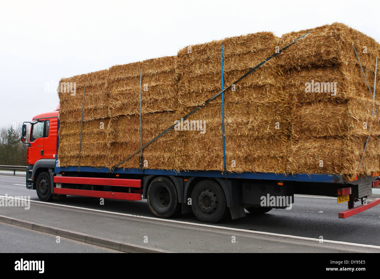 An unnamed flatbed truck carrying a load of hay bales along the A46