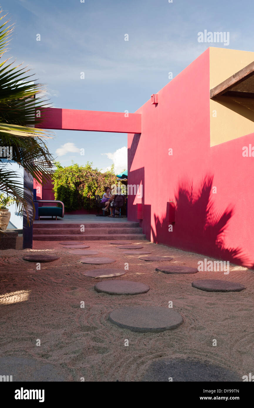 Inner courtyard of Hotelito with round paving stones and pink walls Stock Photo