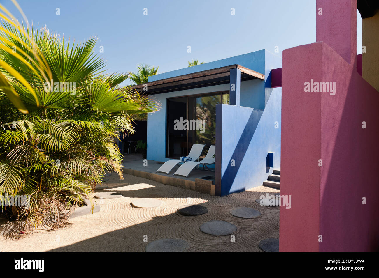Inner courtyard of Hotelito with round paving stones and pink walls Stock Photo