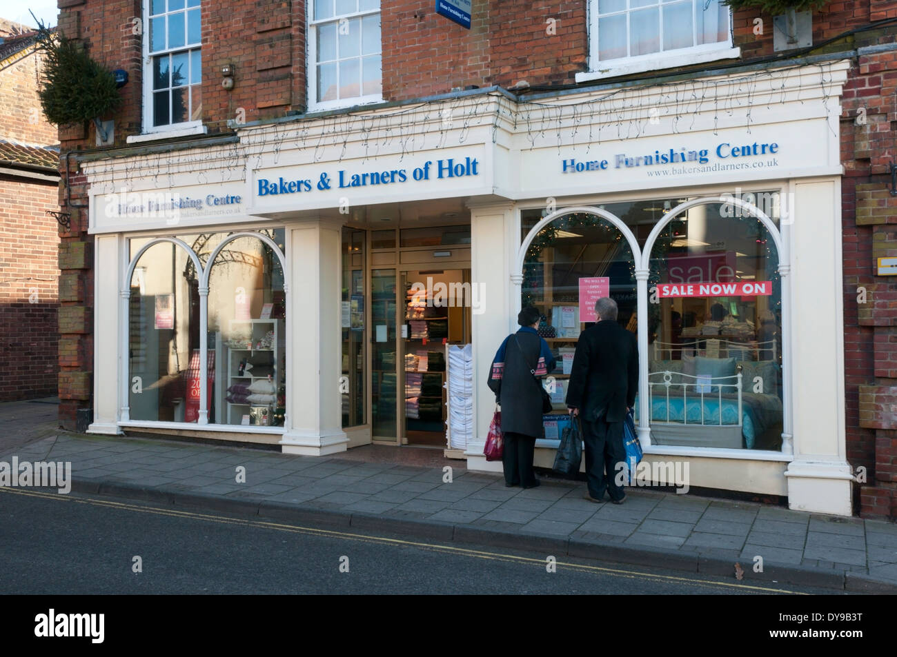 Two people looking in the window of the furnishing shop of Bakers & Larners of Holt, Norfolk Stock Photo