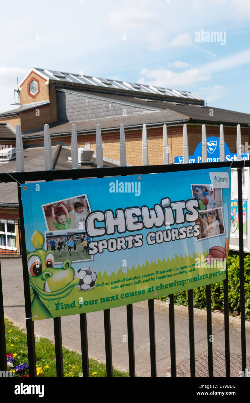 Sign for sports courses sponsored by Chewits sweets at school gates. Stock Photo
