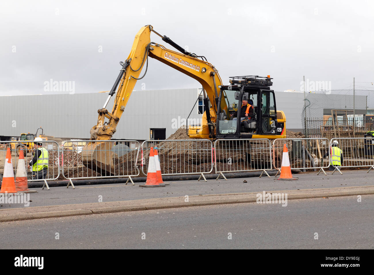 A mechanical digger excavating earth on a construction site in Scotland, UK Stock Photo