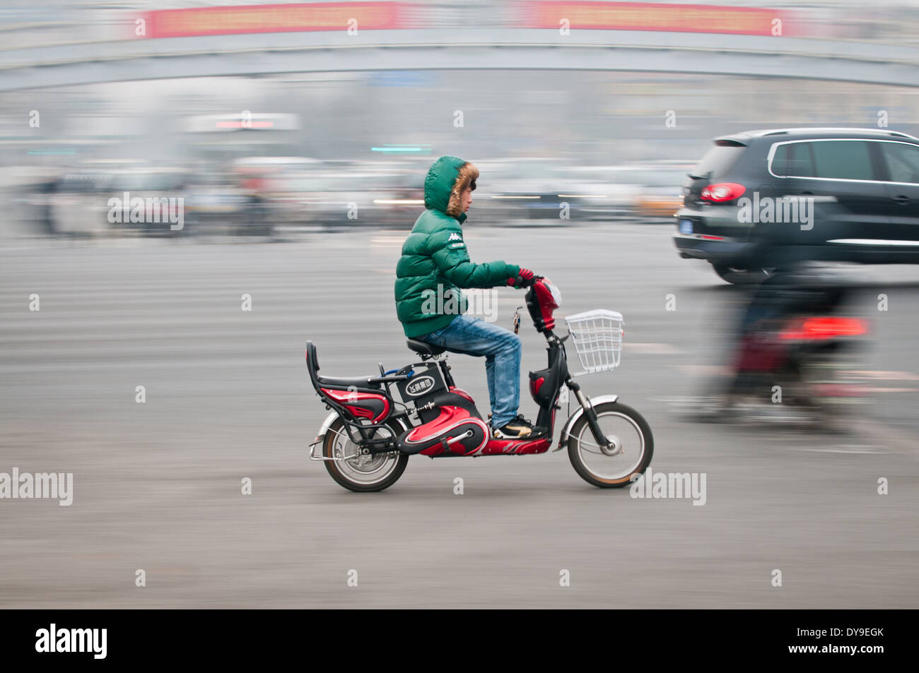 young chinese man riding on a moped in Beijing, China Stock Photo - Alamy