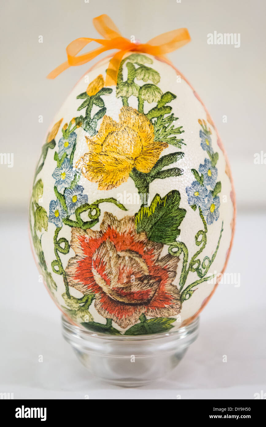 Easter egg decorated with flowers made by decoupage technique on light