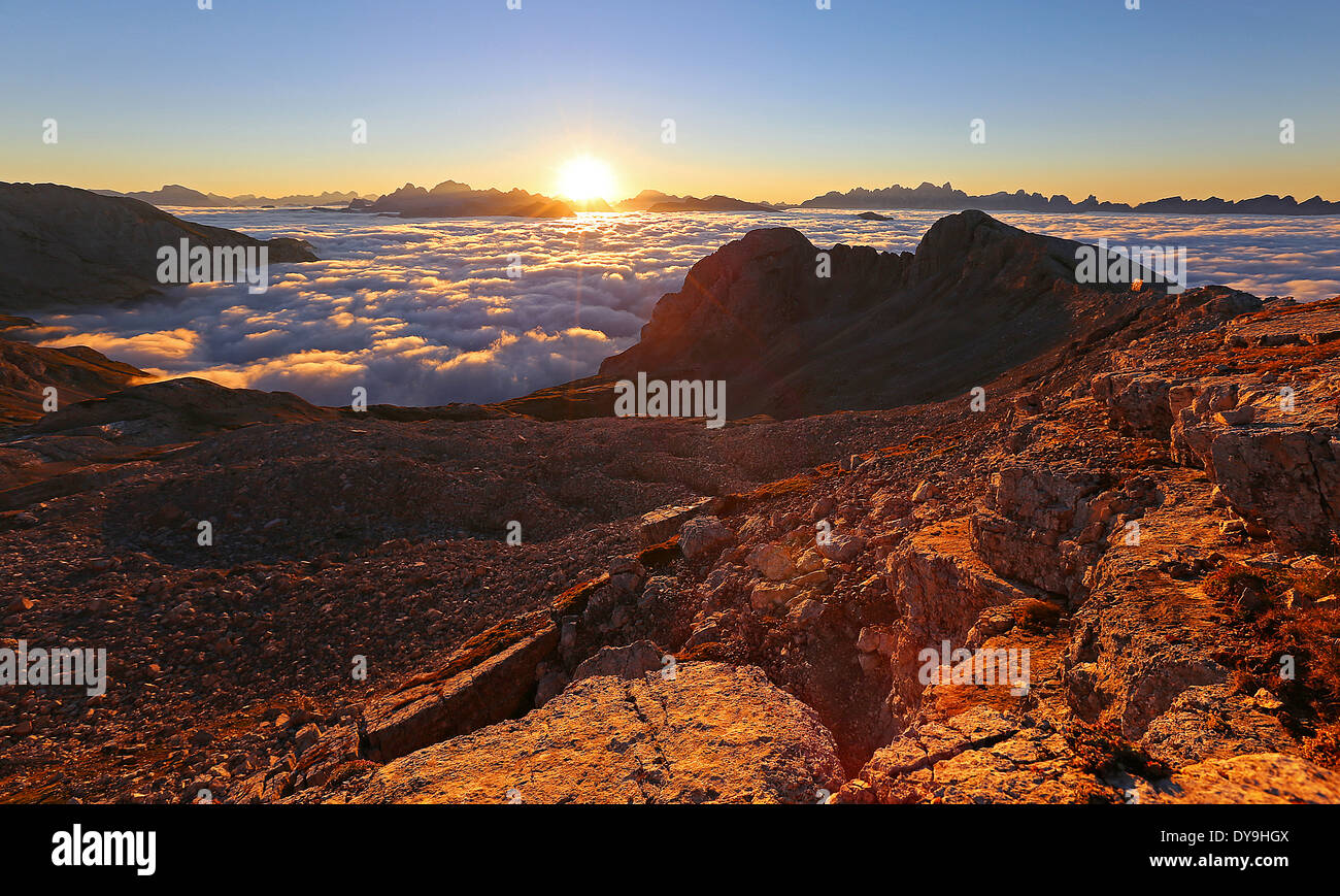 Latemar mountain group, karst rocks. Sunrise on the Dolomites,a tide of clouds over the Fiemme and Fassa valley. Trentino. Italian Alps. Stock Photo