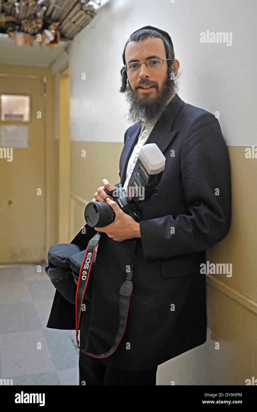 A religious Jewish photographer with his camera and flash in Borough