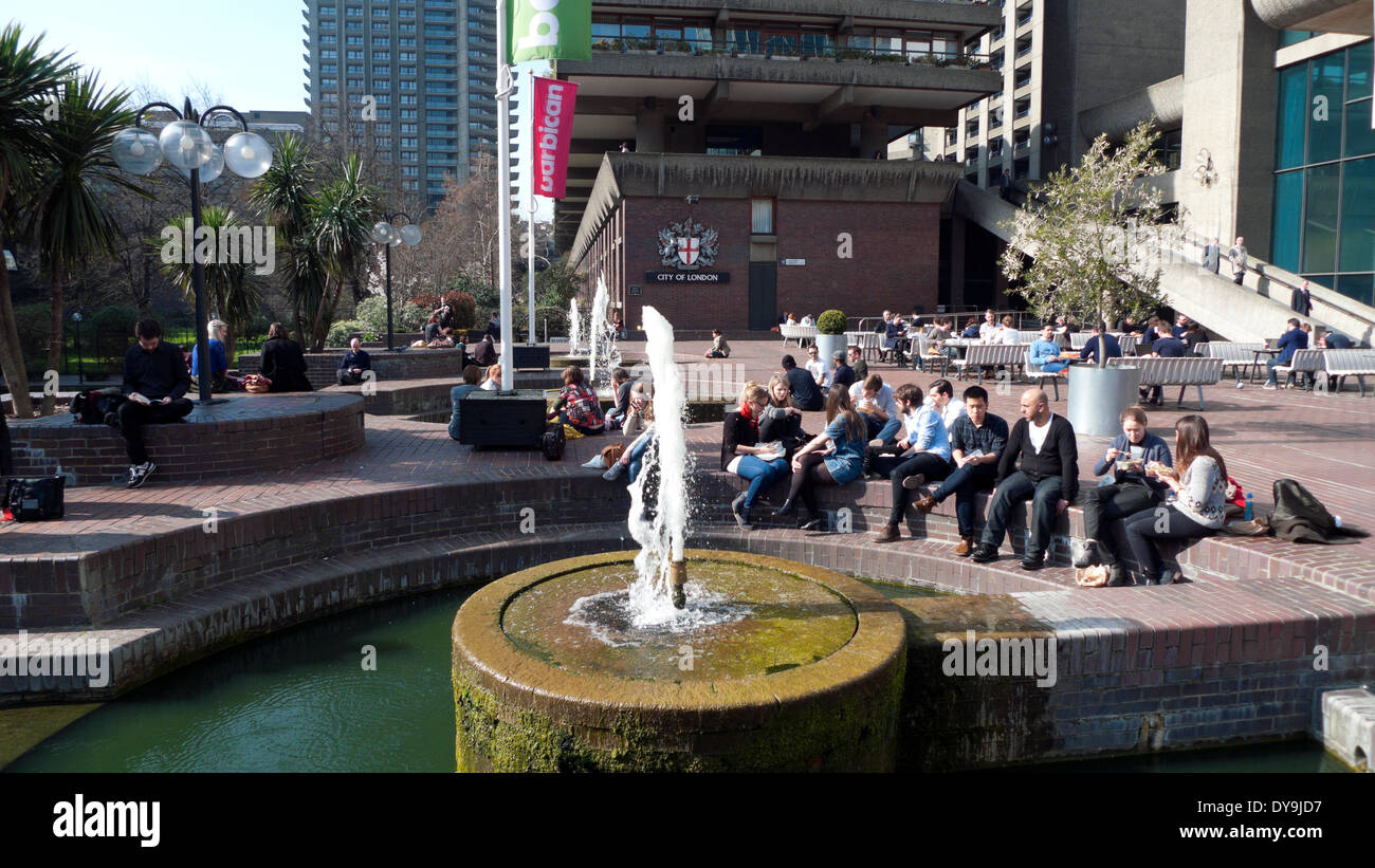 People sitting by the fountain in the sunshine outside the Barbican