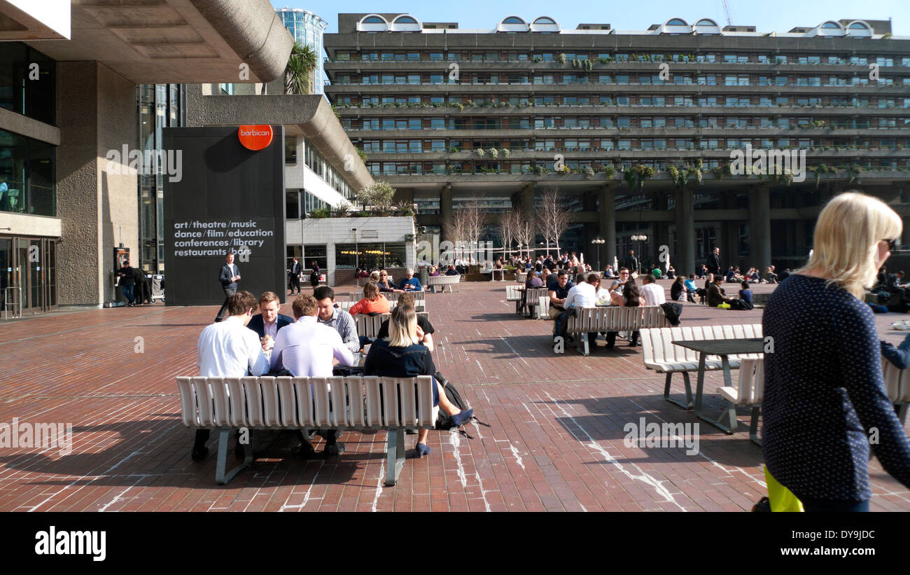 People sitting at tables lunchtime in the sunshine outside the Barbican Centre London England UK KATHY DEWITT Stock Photo