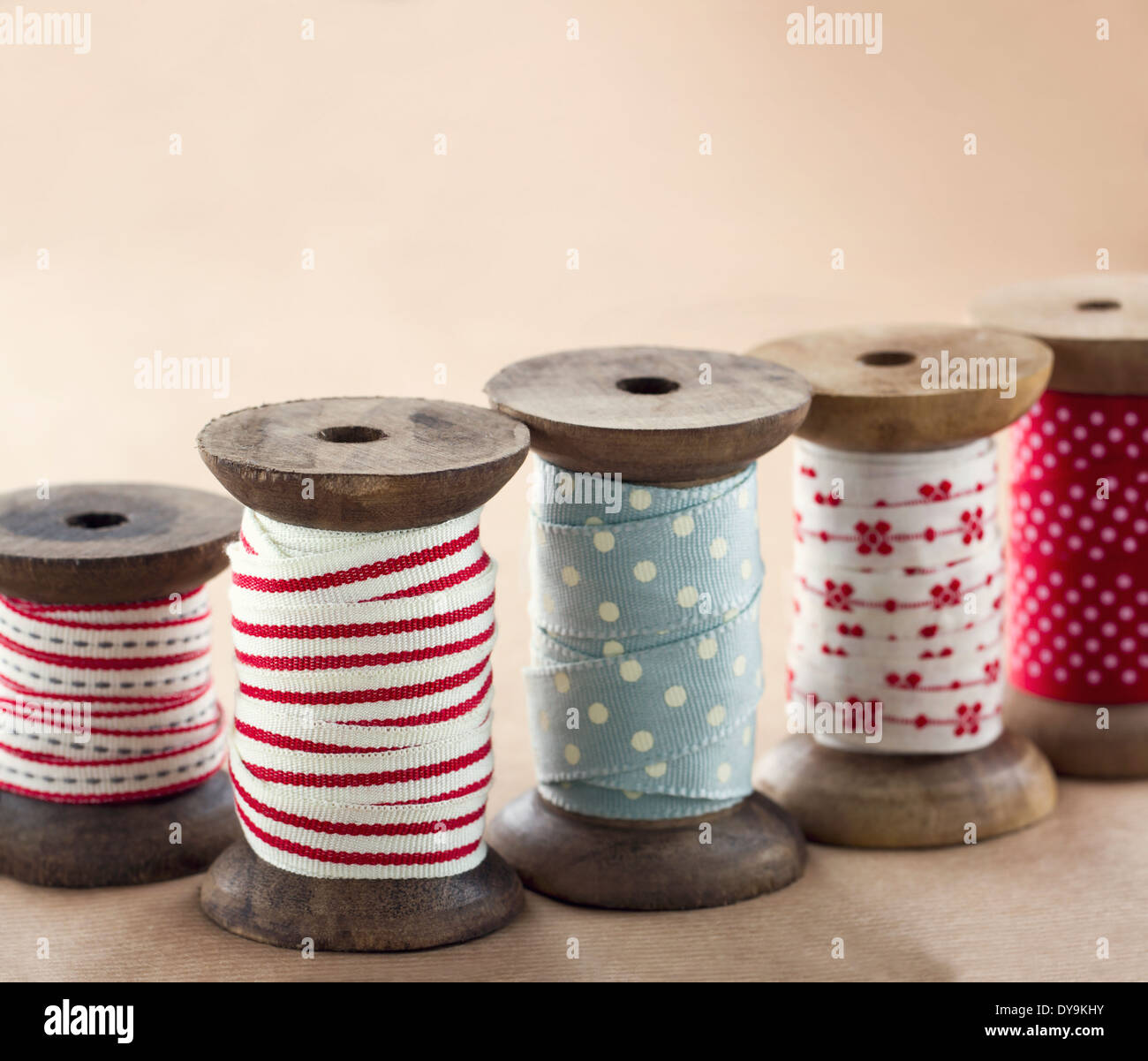 Wooden ribbon spools for Christmas present wrapping on brown vintage background Stock Photo