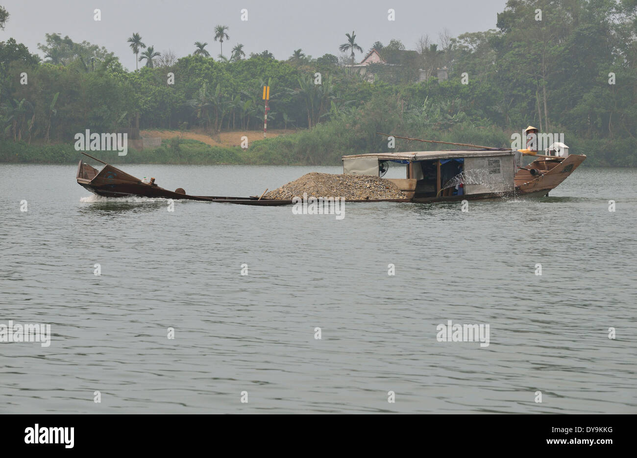 Working river boats carrying  river dredged gravel  to Hue ,on the Perfumed River, Hue, Vietnam Stock Photo