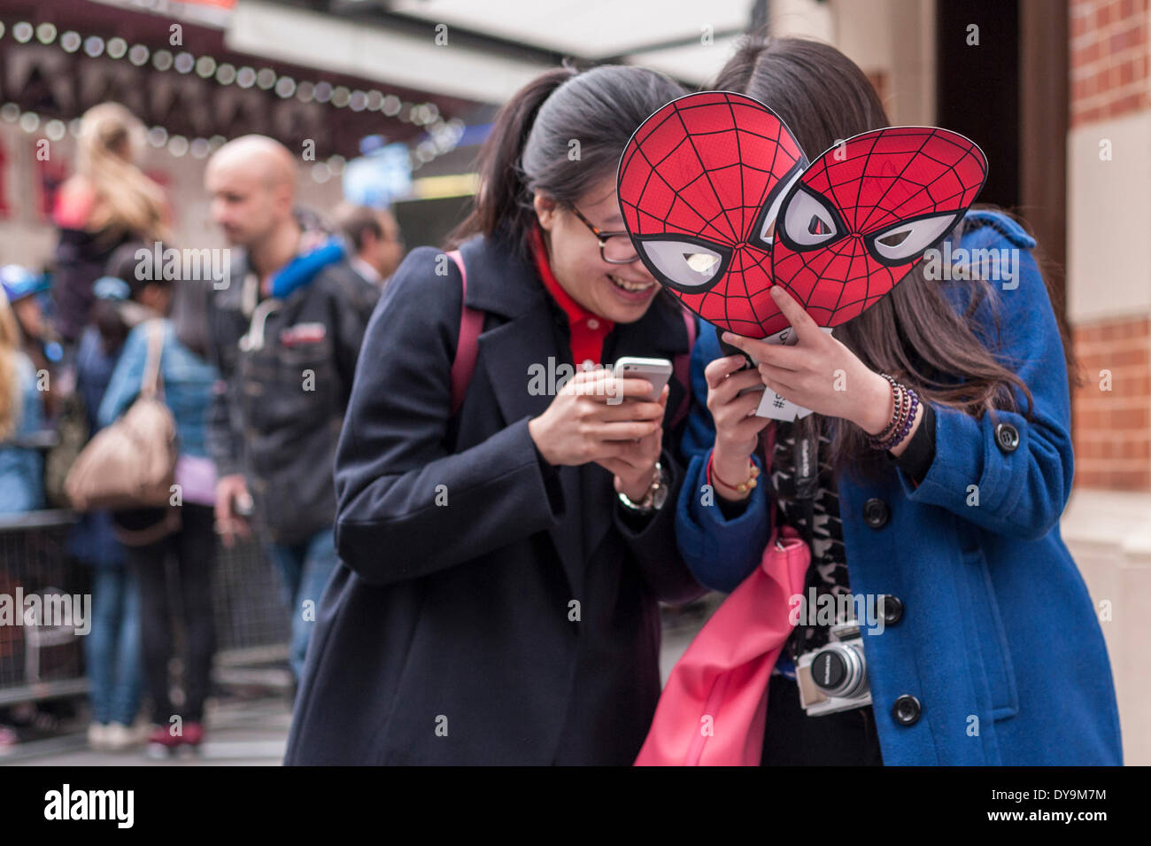 Leicester Square, London, UK, 10 April 2014.  Crowds gather to see the stars of  'The Amazing Spider-Man 2' movie which was having its world premiere.  These two girls were excited to snap a photo of their comic book superhero. Credit:  Stephen Chung/Alamy Live News Stock Photo