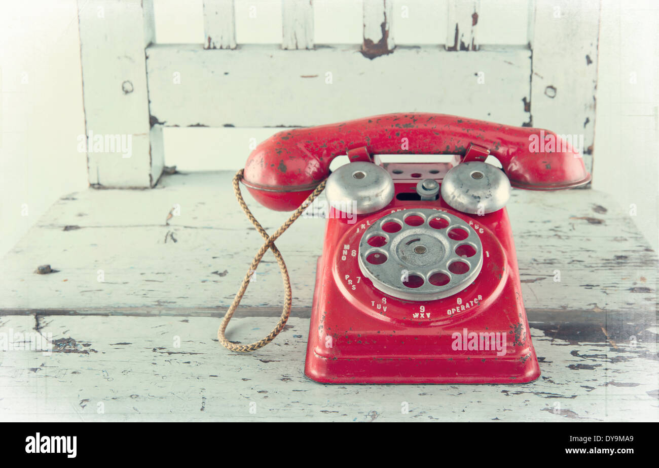 Red toy telephone on old light blue wooden chair with vintage editing Stock Photo