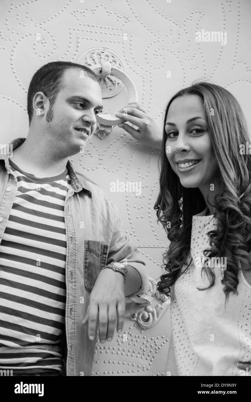 Photo of a wedding couple in black and white looking at camera, smiling