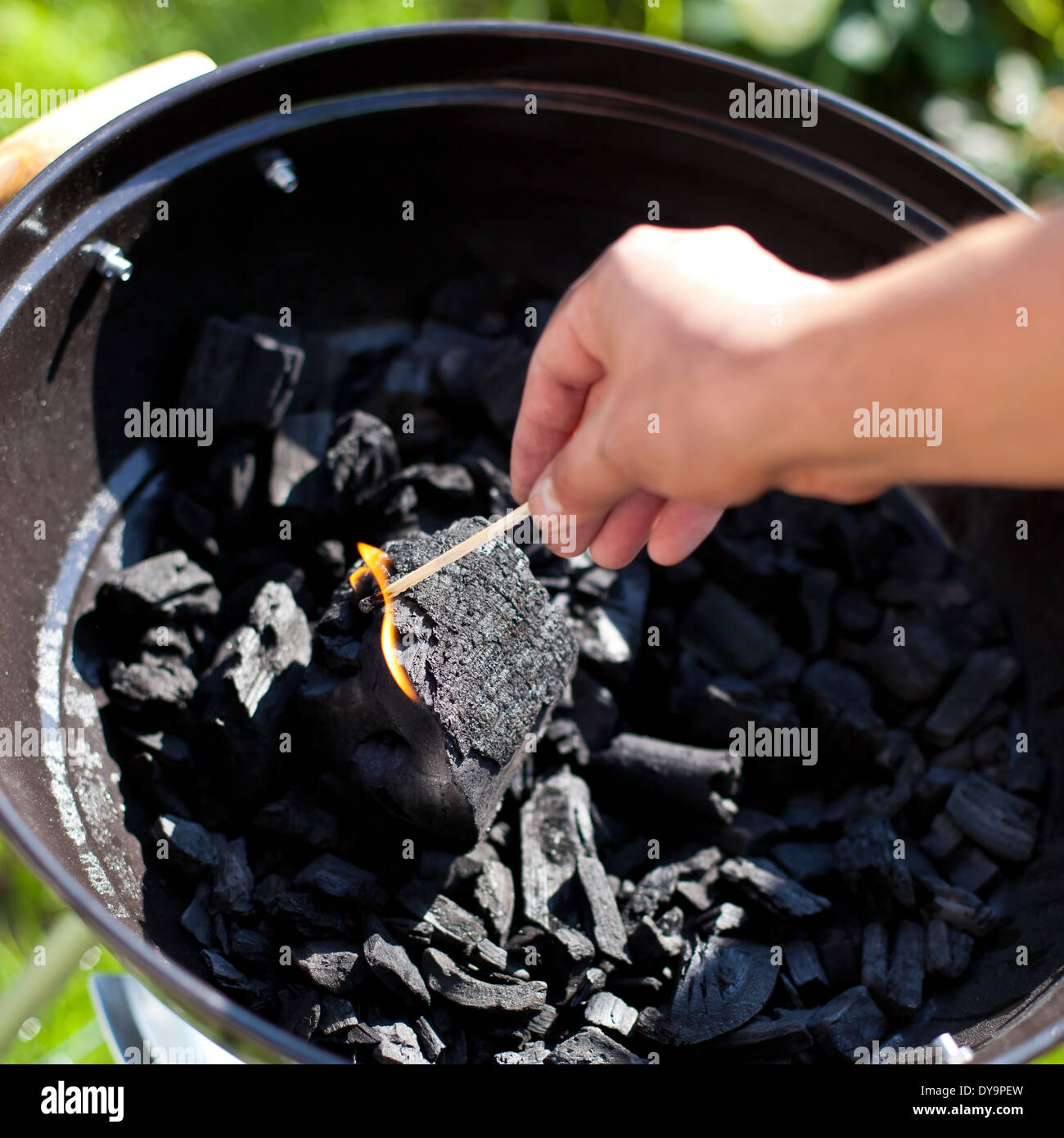 Striking a matchstick, burn up a charcoal in barbecue grill, prepare