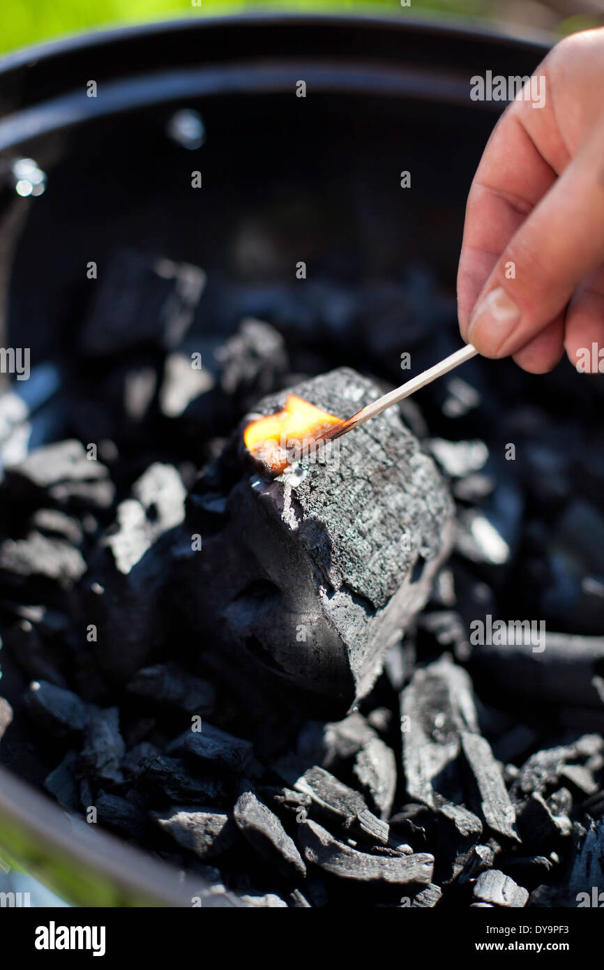 Striking a matchstick, burn up a charcoal in barbecue grill, prepare