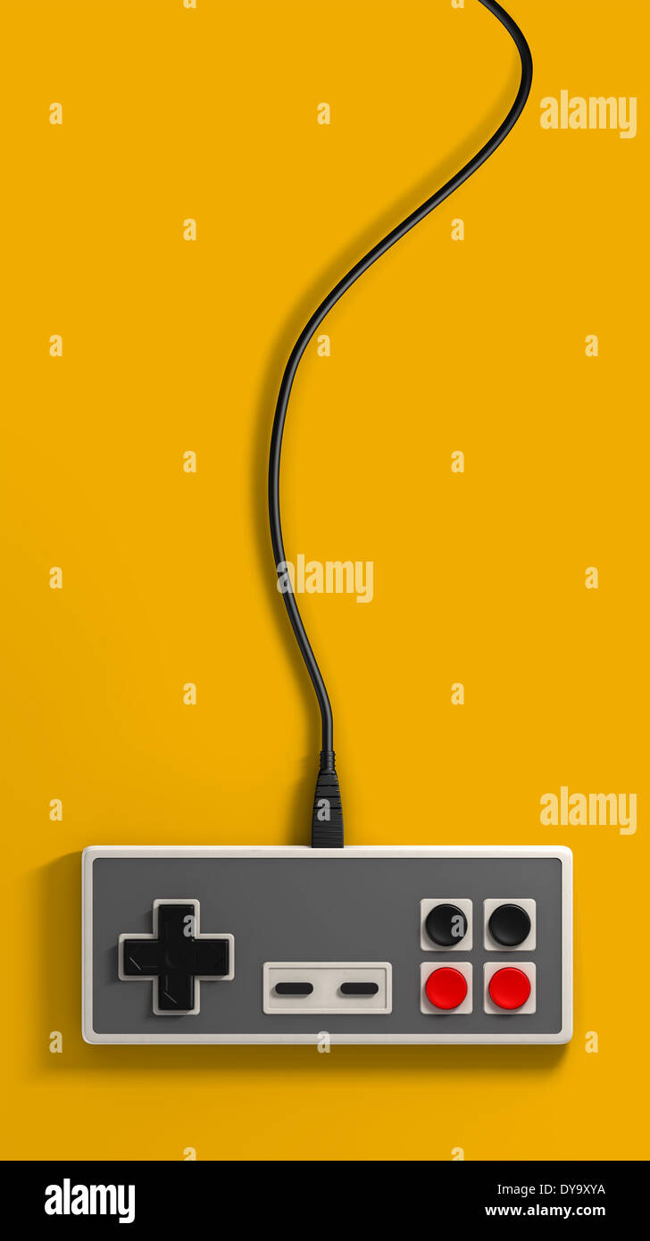 A regular vintage rectangular gaming controller with red and black buttons on an isolated yellow studio background Stock Photo