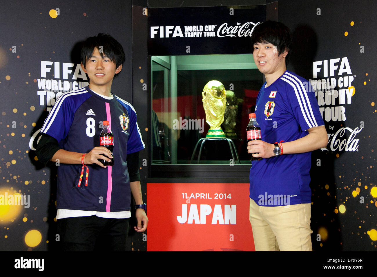 Tokyo, Japan. 11th Apr, 2014. Visitor pose for the cameras next to the World Cup trophy during the 'Coca Cola Cup Trophy' event in Shibuya, on April 11, 2014. The tour will be release in Tokyo and Rikuzentakata Tohoku on April 12 under the theme 'Tournament Everyone Lead' to send the spirit to the world from the Northeast Japan. Credit:  Rodrigo Reyes Marin/AFLO/Alamy Live News Stock Photo